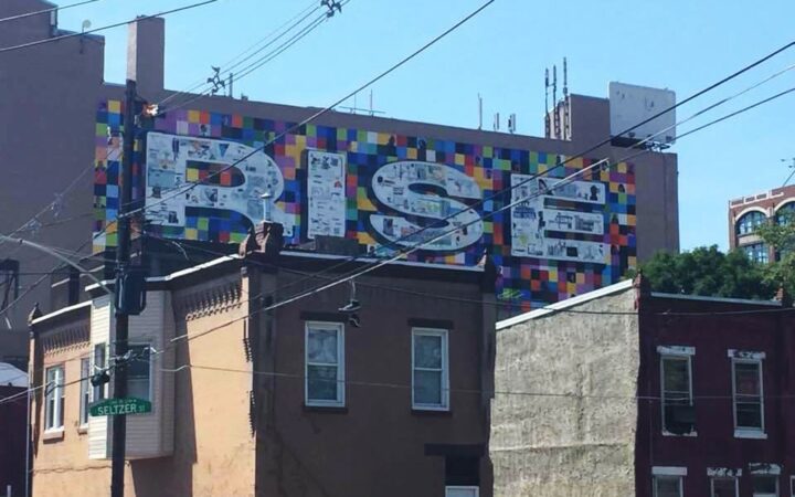 Mural on building wall depicting the word RISE